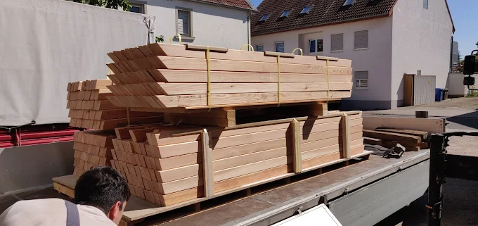 Eine große Lieferung Holz auf einem LKW wird abgeladen