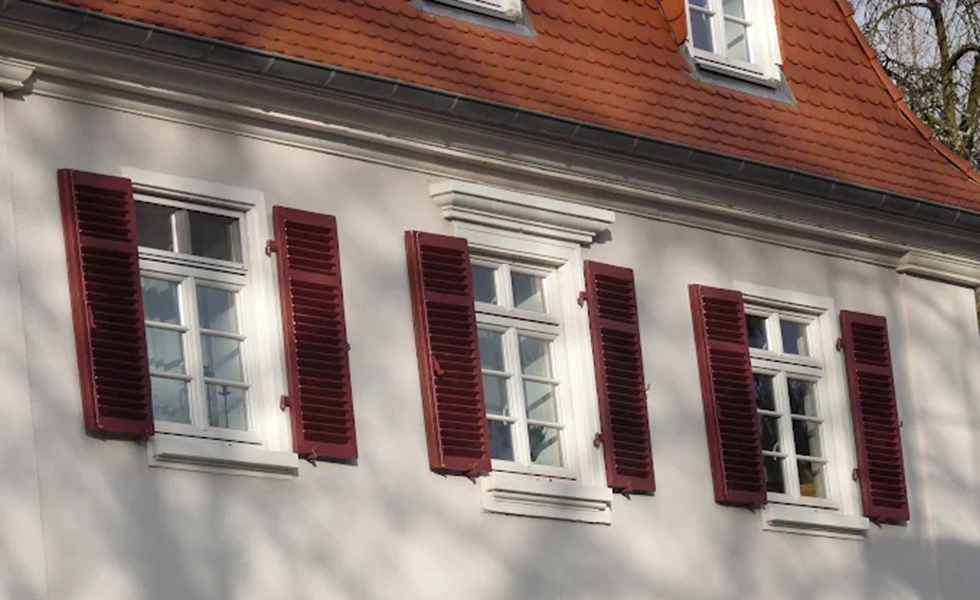 Sanierte rote Fensterläden eines Einfamilienhaus