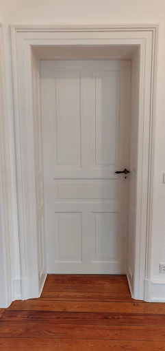Eine Tür in einer Altbauwohung wurde weiß gestrichen