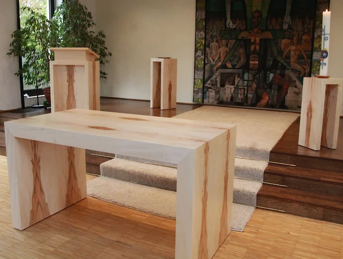 Ein holzgefertigter Kirchenaltar im Foyer einer Kirche.